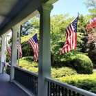 Front porch of Captains Manor inn adorned with American Flags